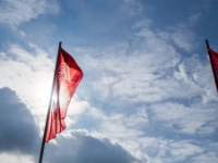 IG Metall-Fahnen vor leicht bewölktem Himmel.