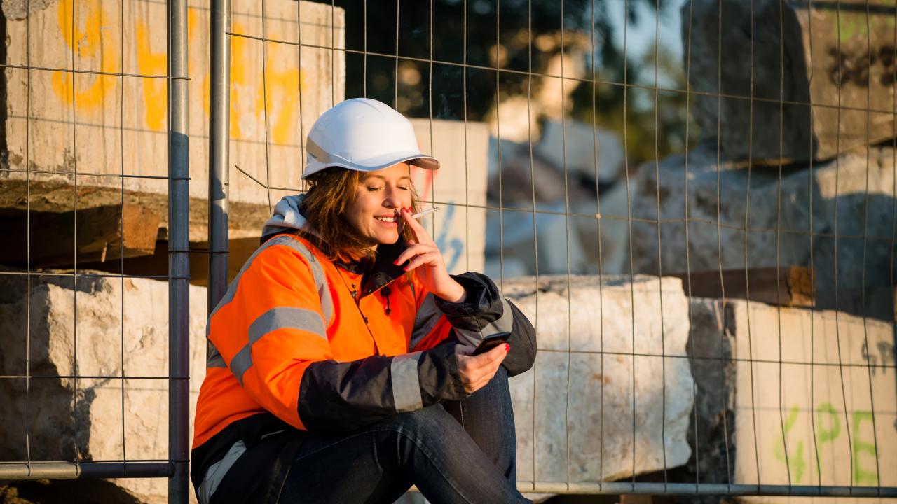 Frau macht an der Arbeit eine Raucherpause